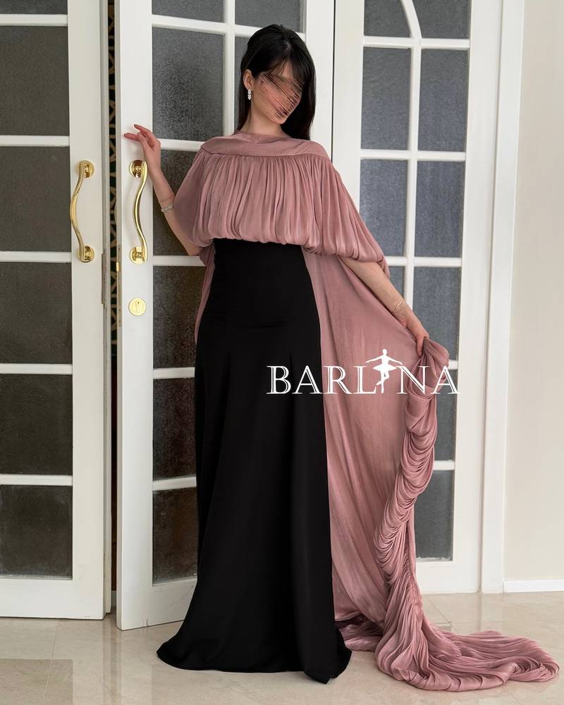 Black dress with a long pink pleated shawl cape