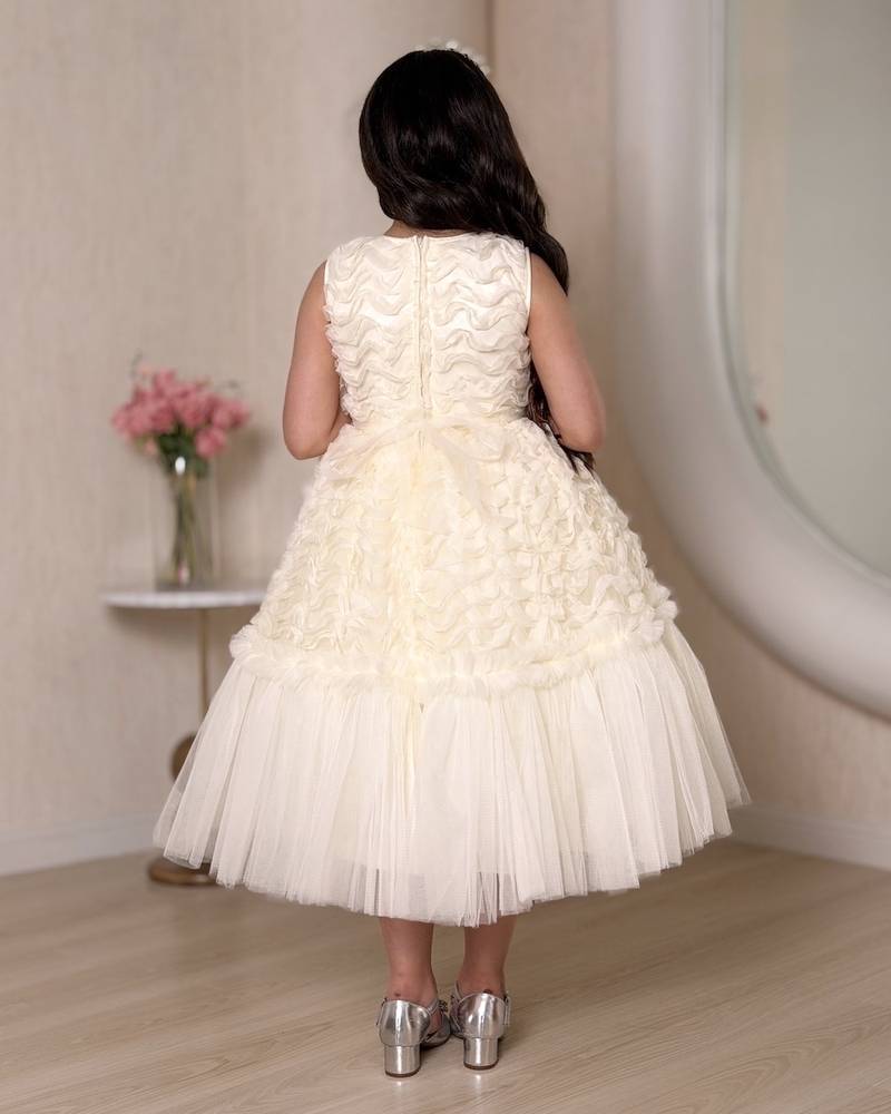 A cream-colored girl's dress adorned with elegant details