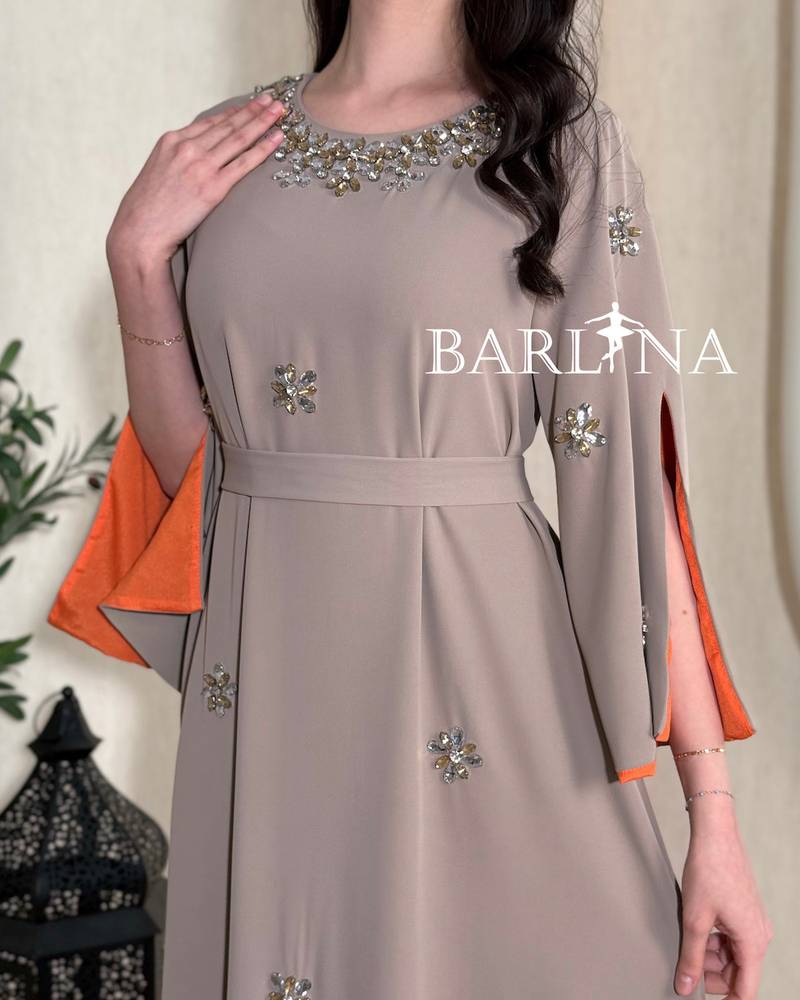 A soft gray jalabiya adorned with delicate embroidery