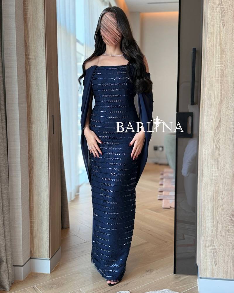 A sparkly navy blue dress with a back cape