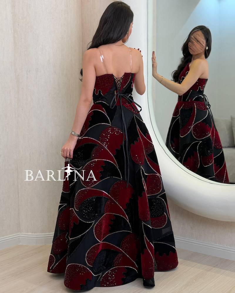 Black dress embroidered with red geometric patterns