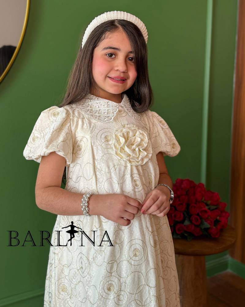 A girl's dress decorated with circle patterns and a raised rose