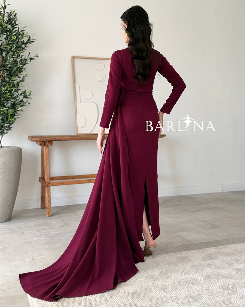 A purple dress adorned with a side flower and a long train.