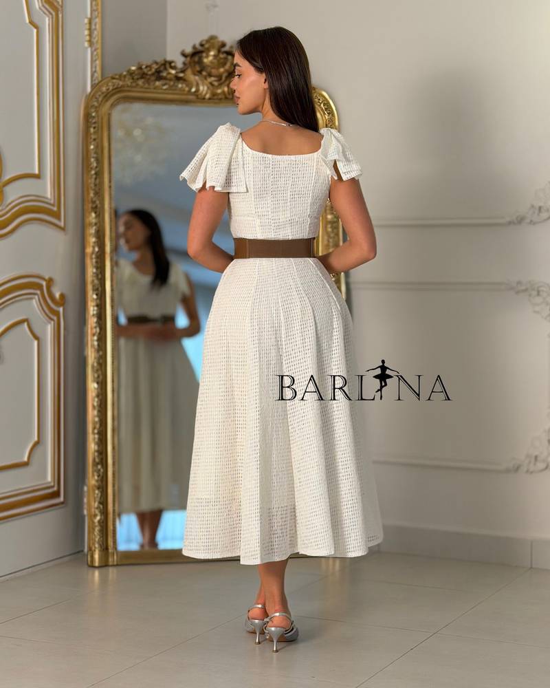 A white dress with soft fabric and ruffled shoulders