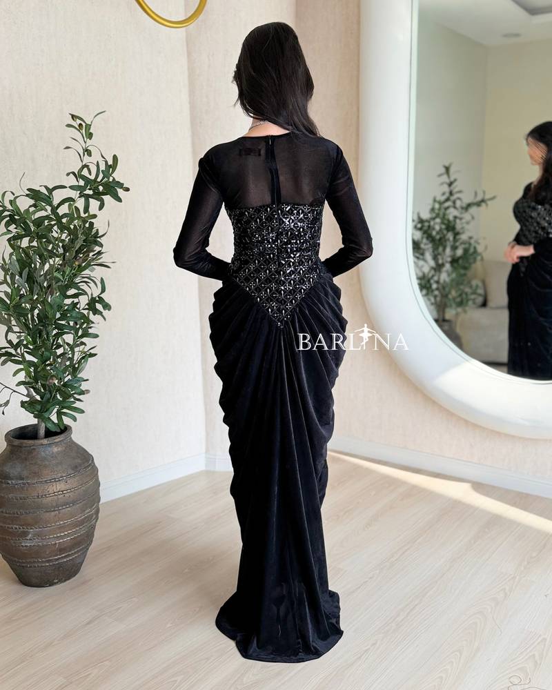 A black velvet dress with a sophisticated sheen and draping.