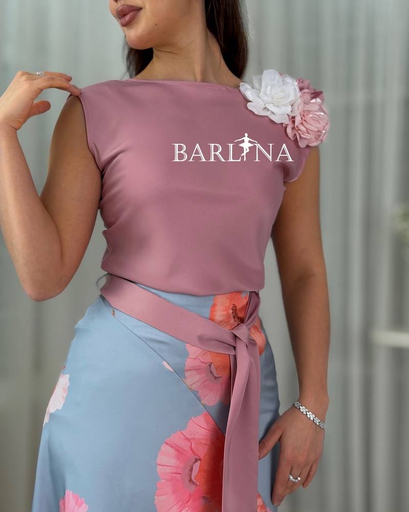 Women's outfit with a light blue floral skirt and a pink blouse