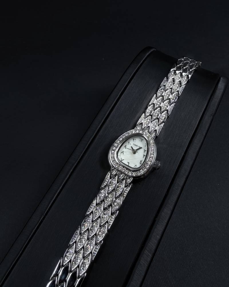 A luxury watch with a geometrically designed studded bracelet.