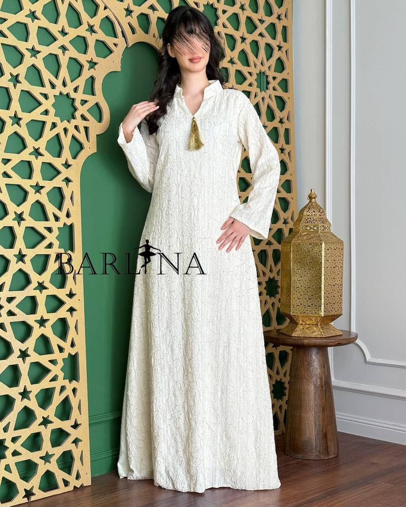 A white jalabiya with delicate embroidery and a straight cut.