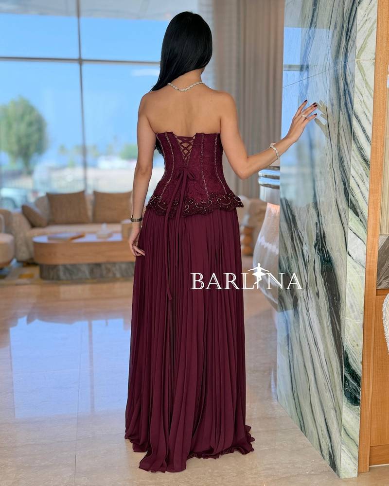 Burgundy dress with multiple pleats and a corset cut