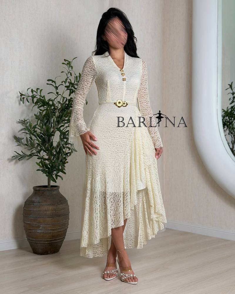 Off-white dress with ruffles at the waist and a gold belt