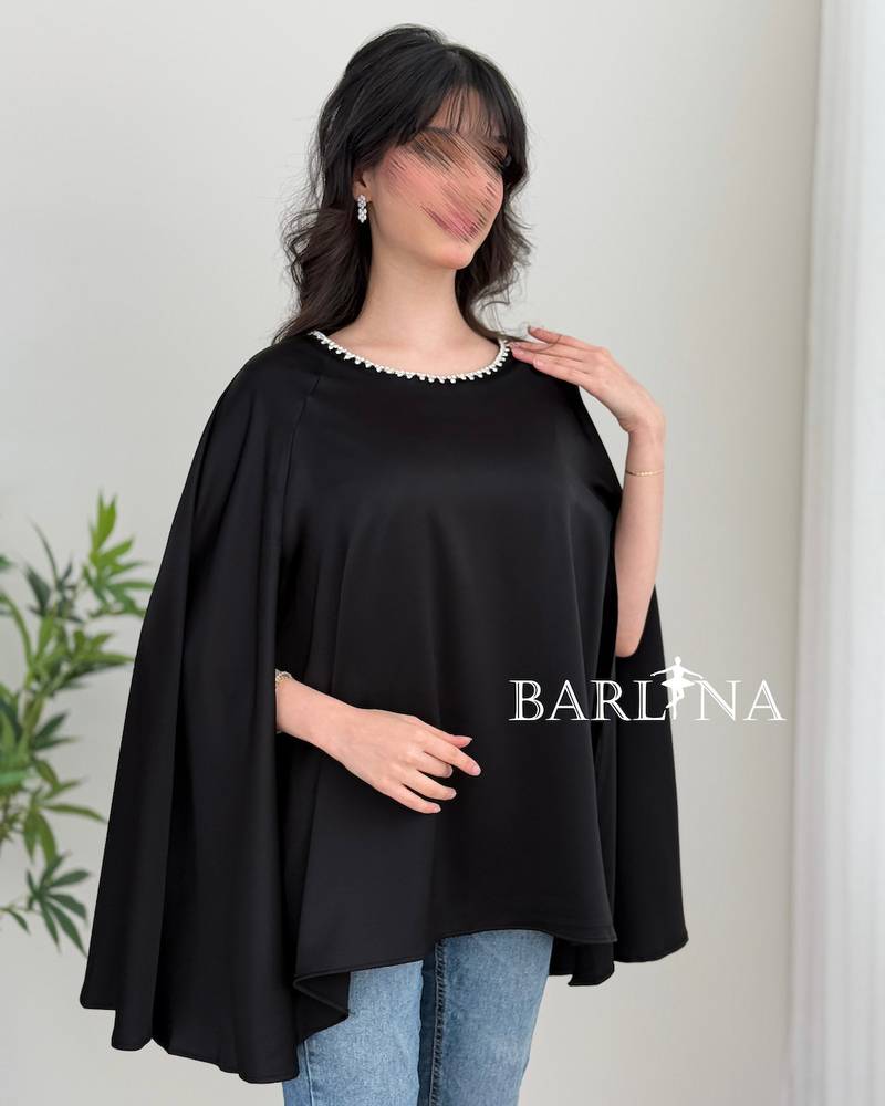 A soft blouse adorned with a pearl trim