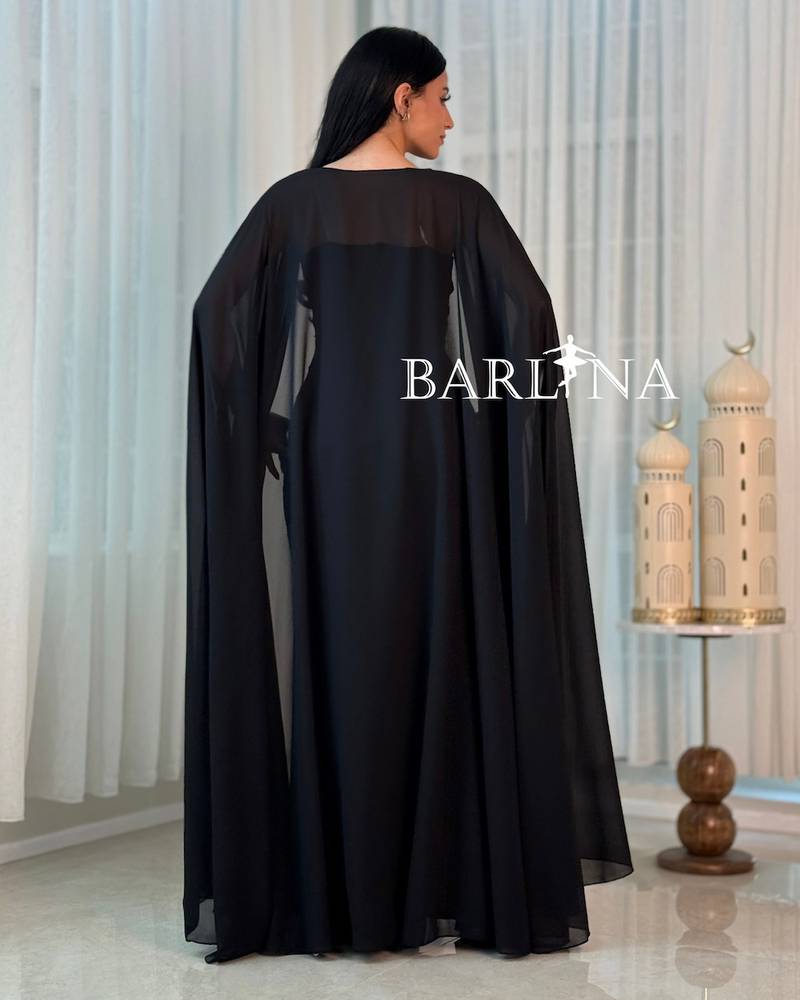 A black jalabiya adorned with luxurious gold patterns