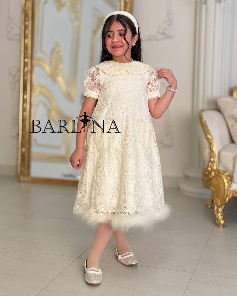 A soft girl's dress with lace and feather trim