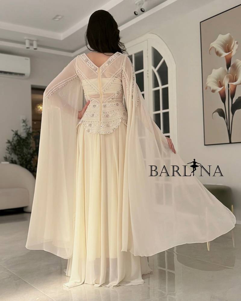 Off-white dress with a royal design and a long cape