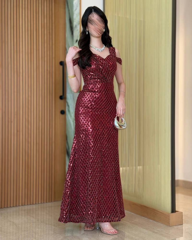 A burgundy dress adorned with sequin patterns and an elegant cut