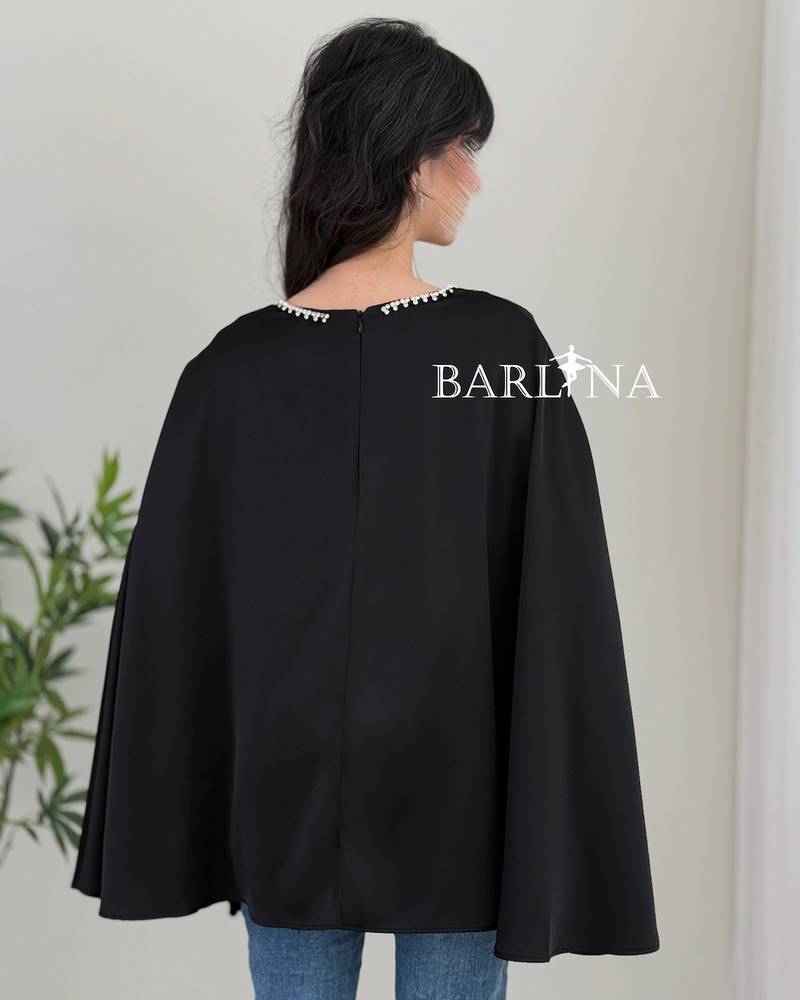 A soft blouse adorned with a pearl trim