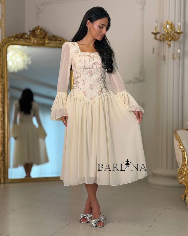 Off-white dress with an embroidered bodice and bell sleeves
