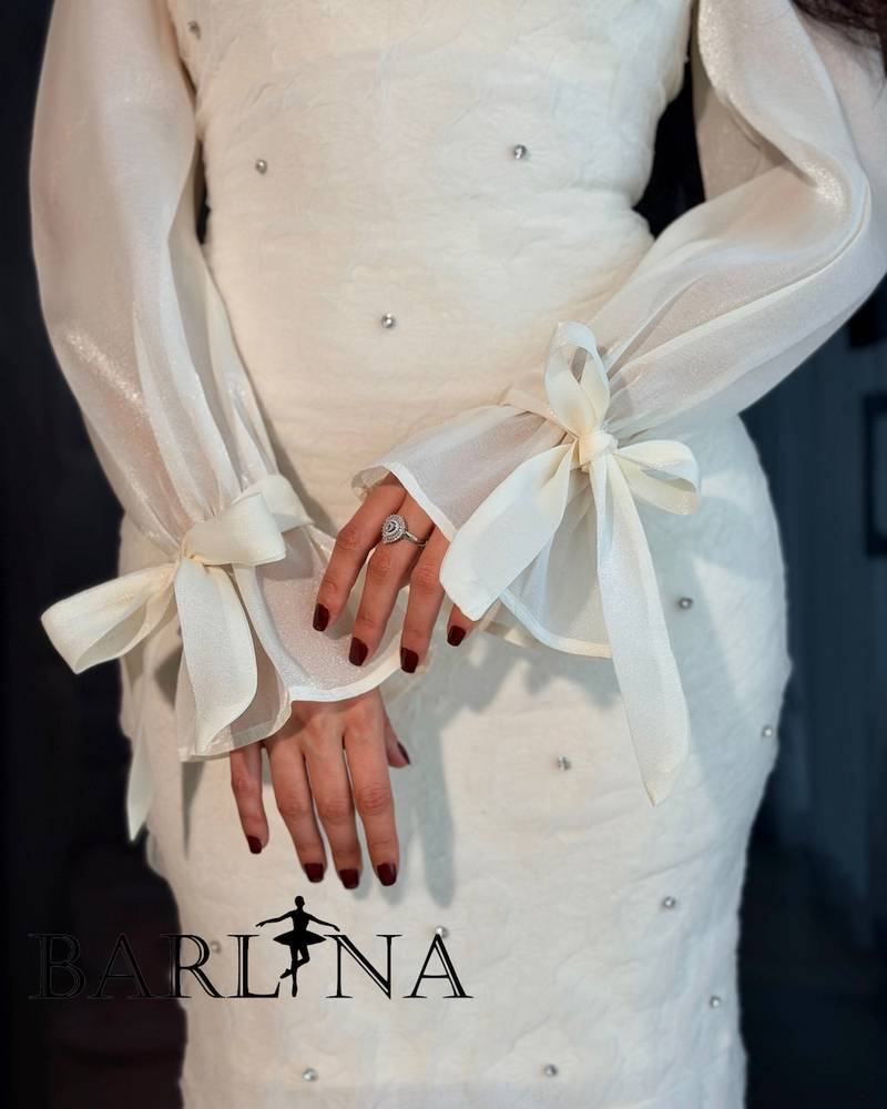 Off-white dress with sheer sleeves and tied cuffs