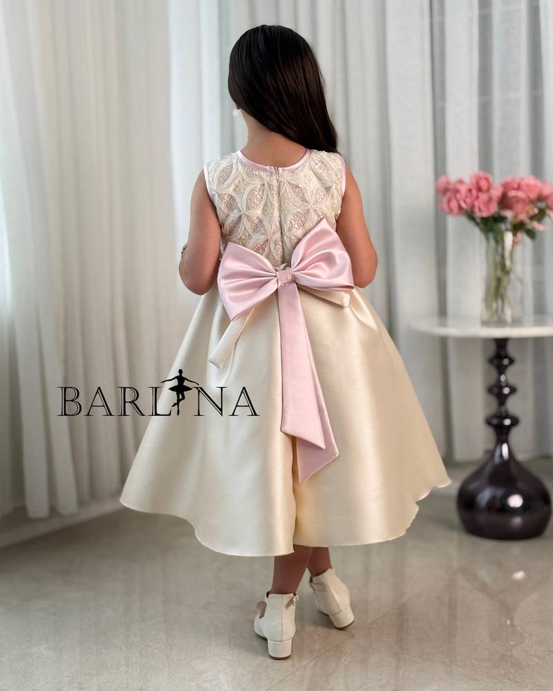 Beige girl's dress decorated with a pink bow