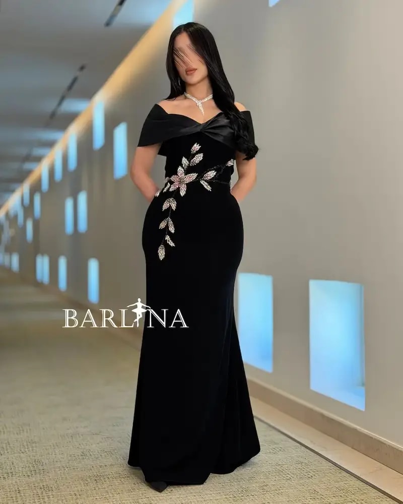 A black dress with a soft cut adorned with shimmering roses.
