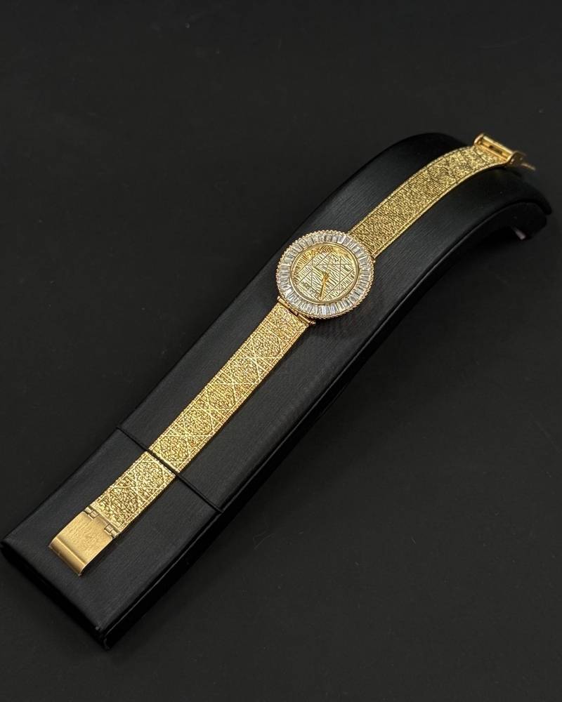 A women's watch adorned with a frame and engraved details