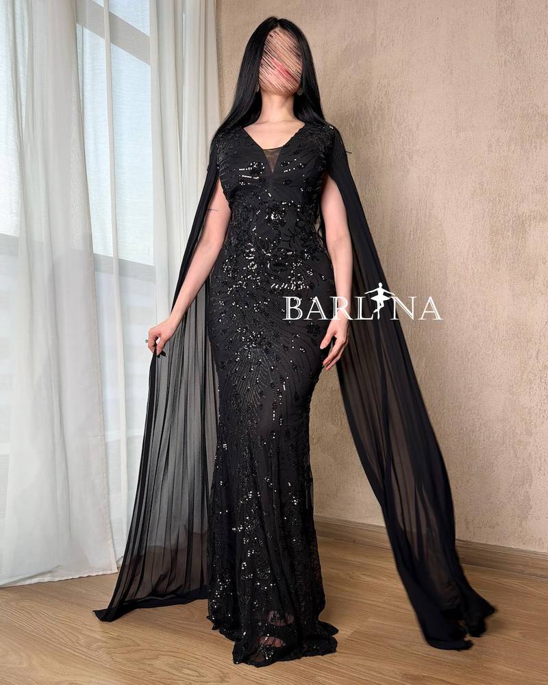 Black dress with shimmering embroidery and a long cape