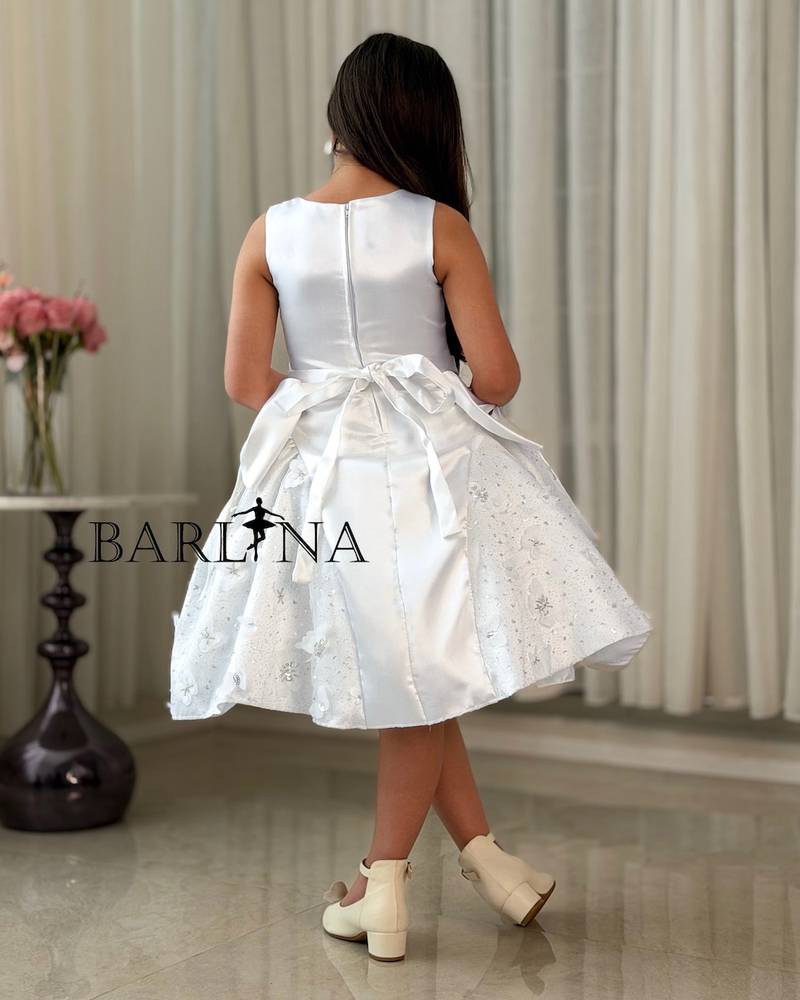 A white, fluffy girl's dress decorated with bows on the sides