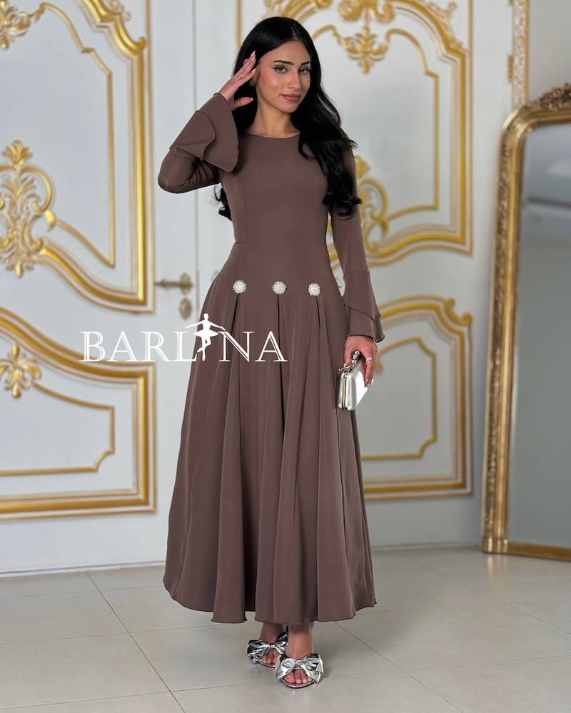 A brown dress with elegant decorative touches at the waist.