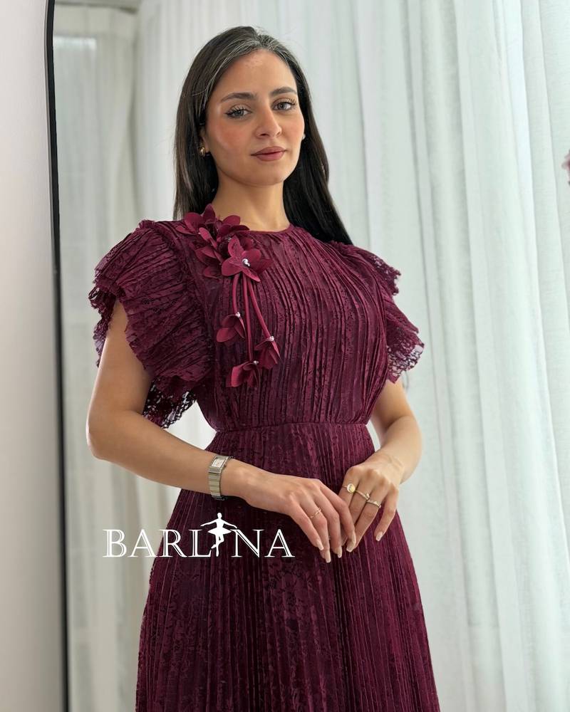 A burgundy dress made of lace fabric with ruffled sleeves