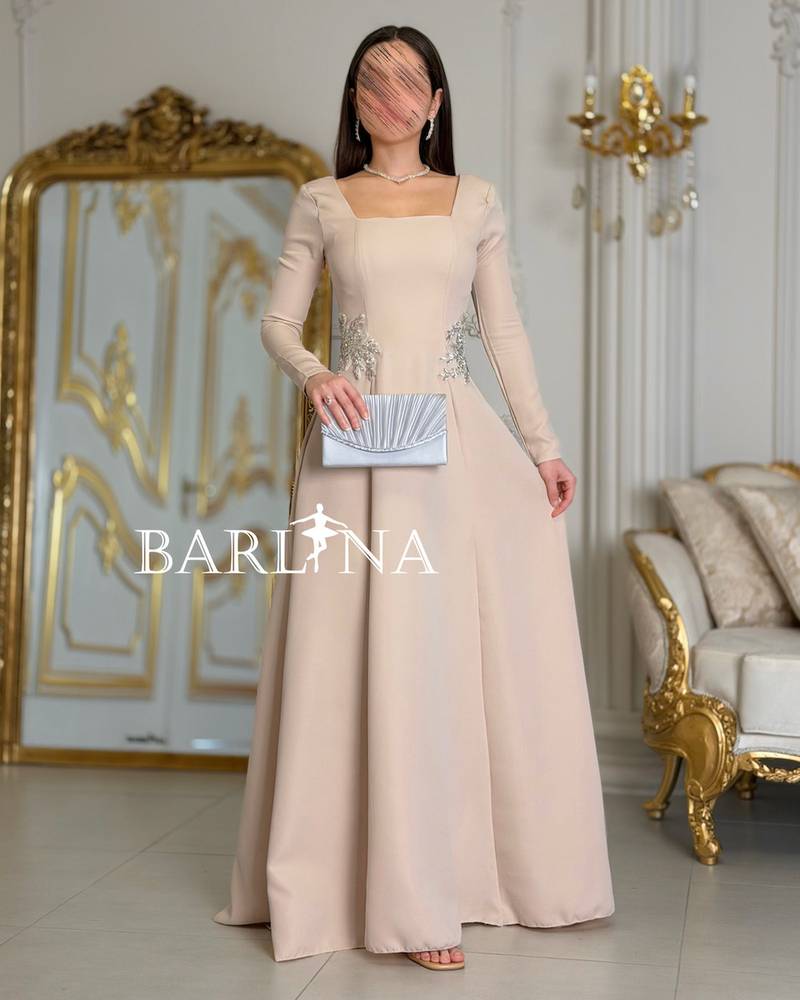 Long beige dress adorned with luxurious embroidery