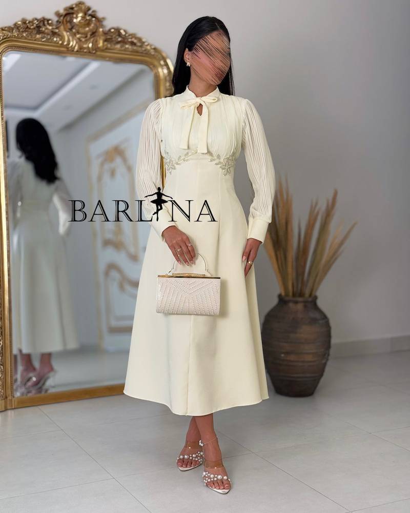 Beige dress with delicate details and sheer sleeves