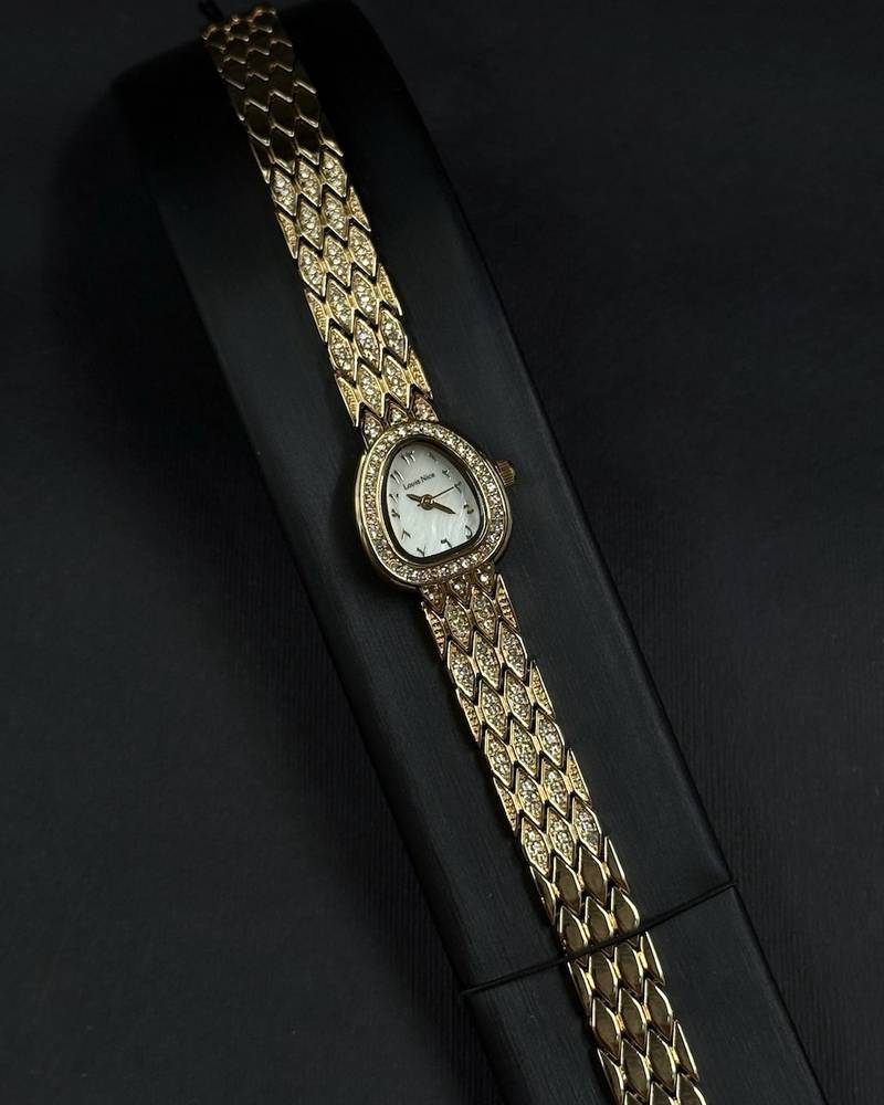 A luxury watch with a geometrically designed studded bracelet.