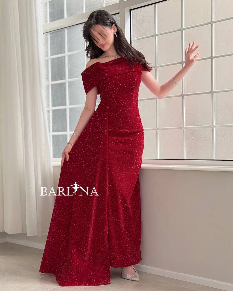Red dress adorned with small rhinestones and a side train