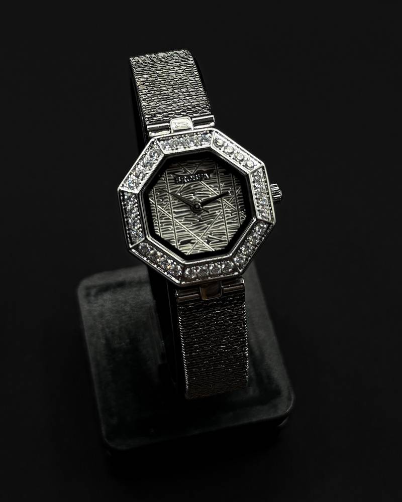 An octagonal bezel wristwatch studded with gemstones