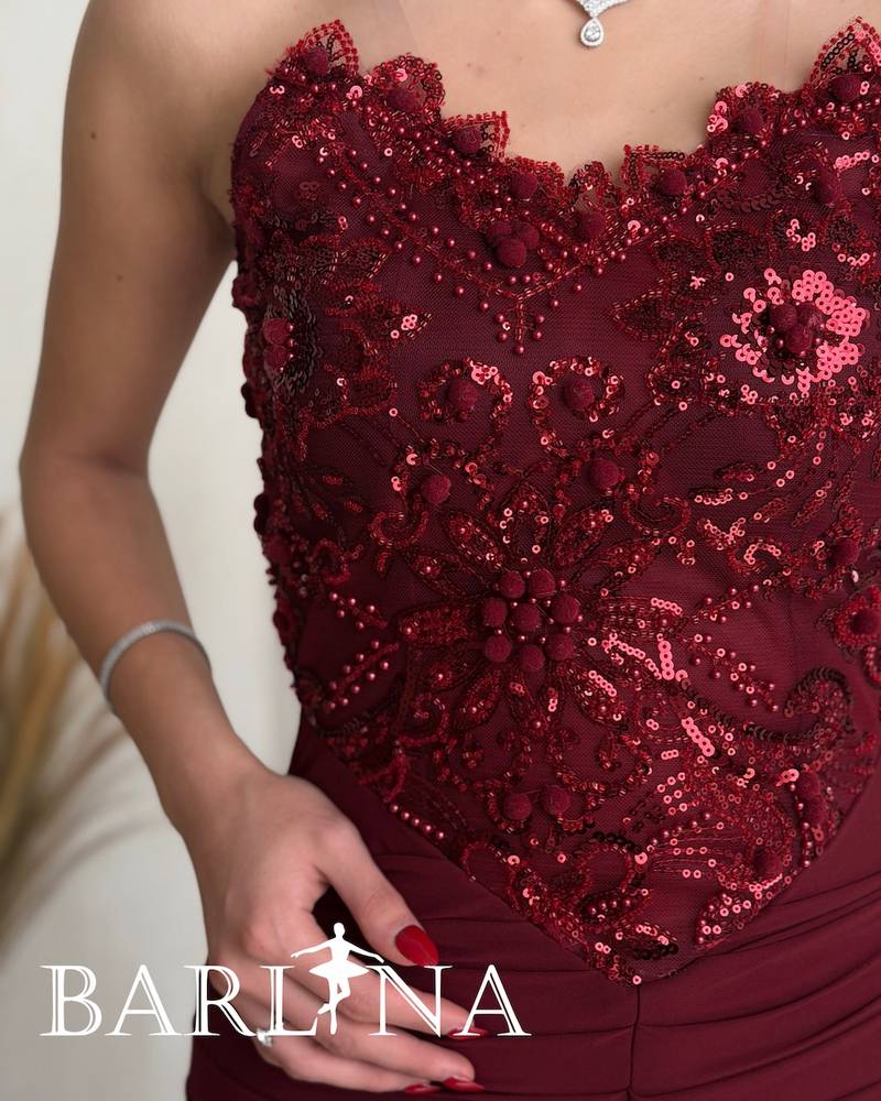 Burgundy dress with a front slit and a gathered design