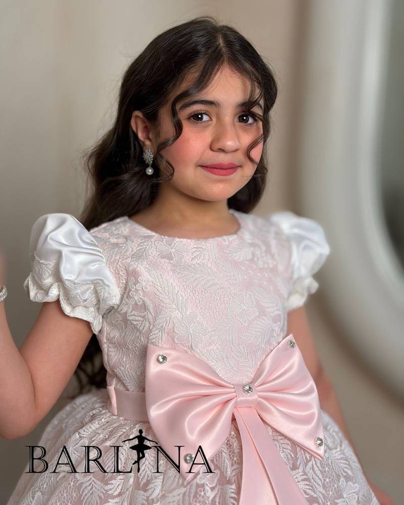 Pink girl's dress decorated with a bow and lace