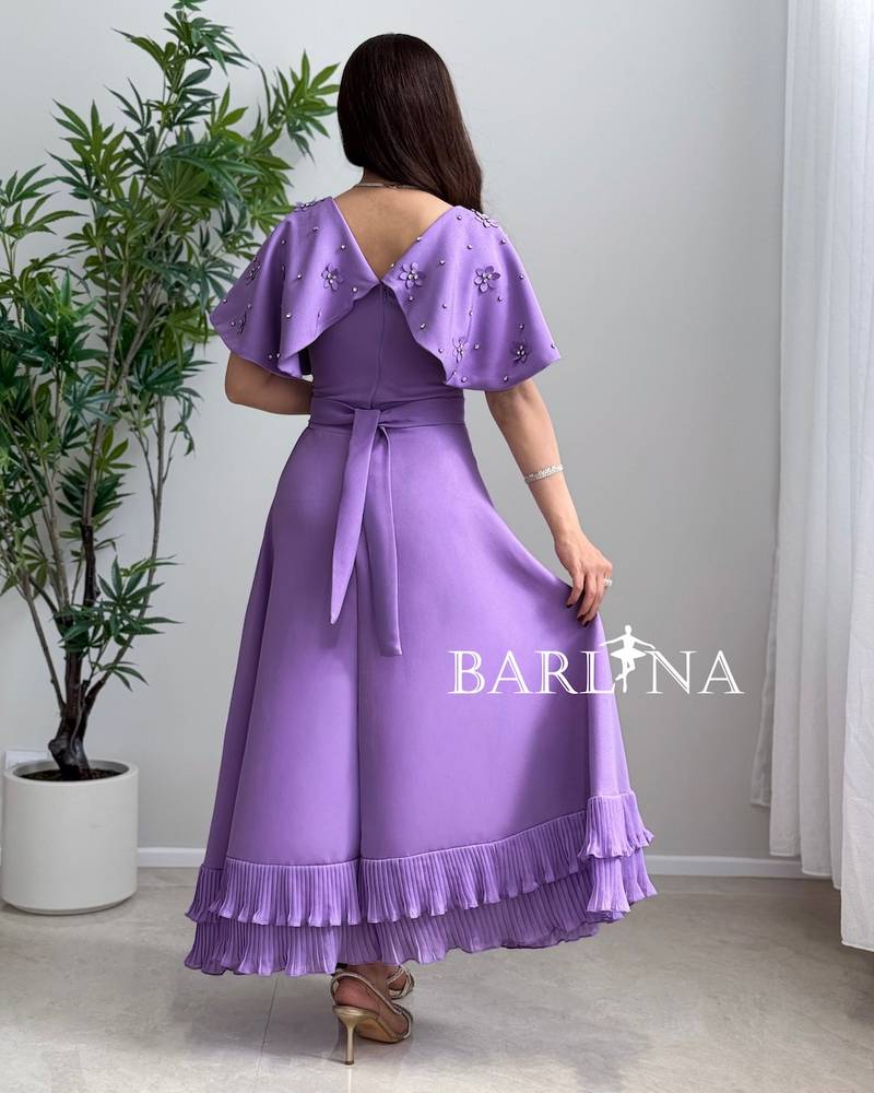 Dress with embroidered cape and pleats at the bottom