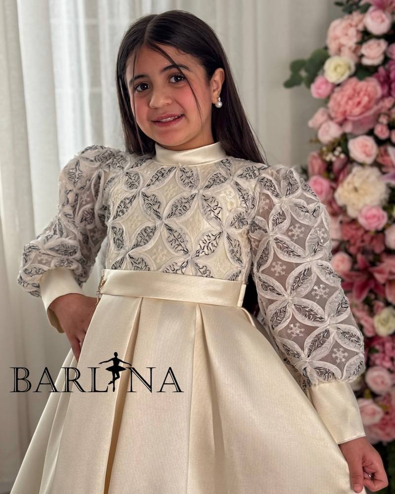 A puffy, off-white girl's dress with geometric patterns