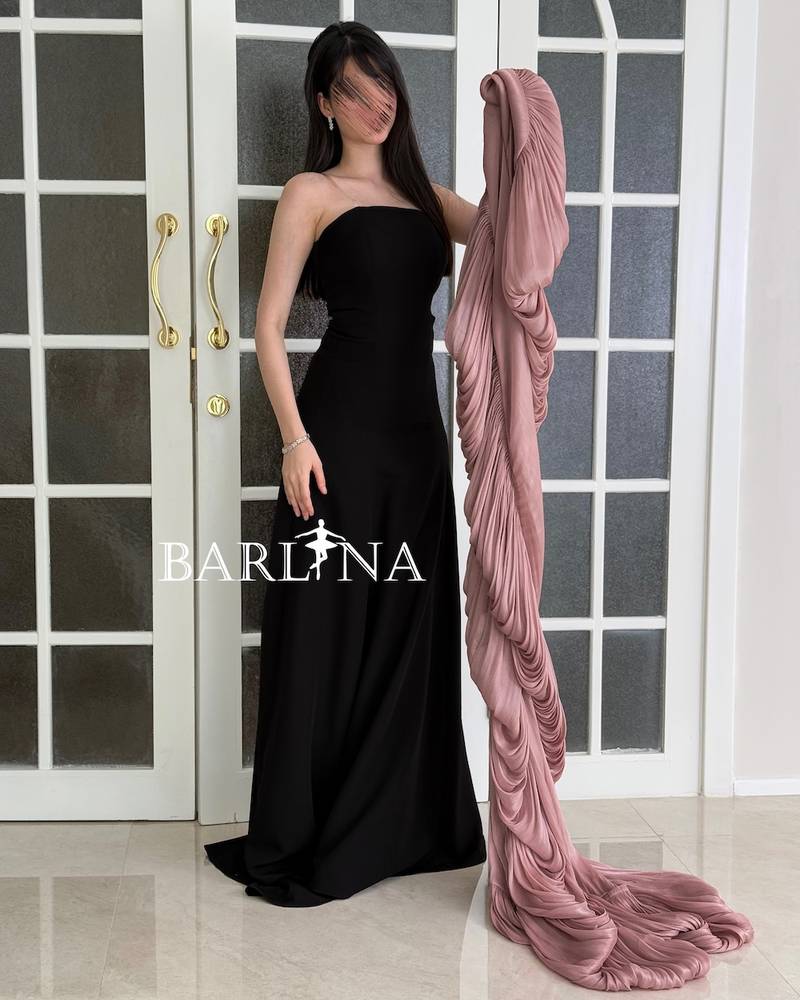 Black dress with a long pink pleated shawl cape