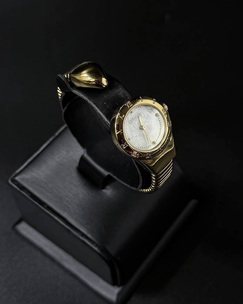 A women's watch with a delicate design and an open strap.