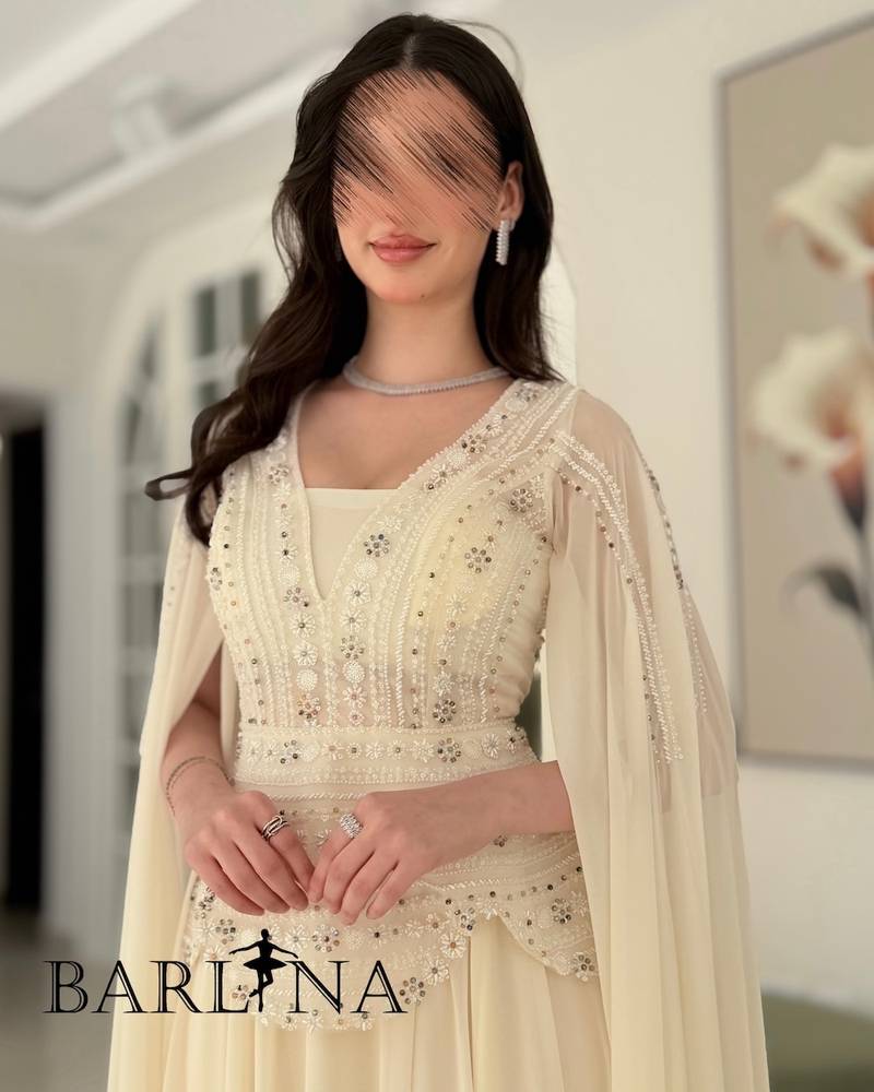 Off-white dress with a royal design and a long cape