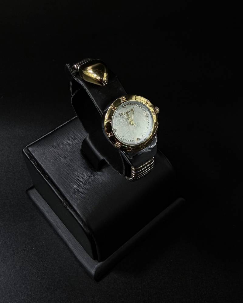 A women's watch with a delicate design and an open strap.