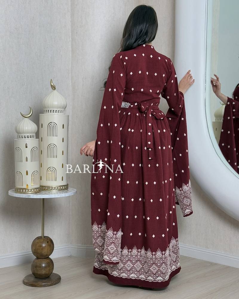 A burgundy-colored jalabiya with scattered patterns