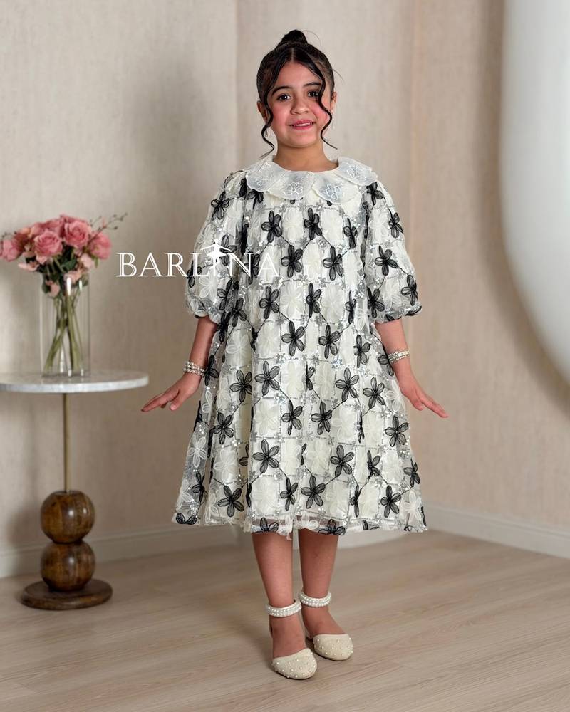 Off-white girl's dress decorated with black roses