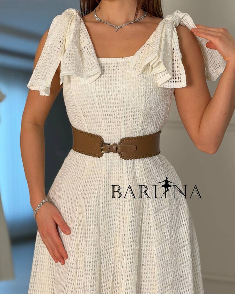 A white dress with soft fabric and ruffled shoulders
