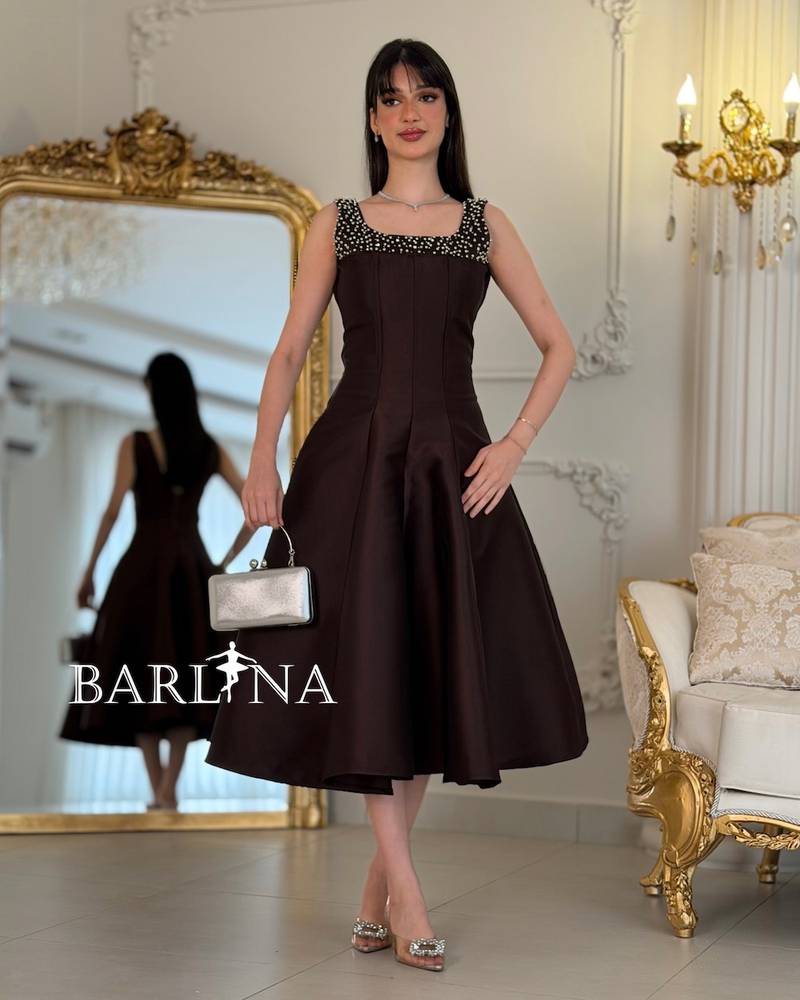 Brown sleeveless dress adorned with pearls