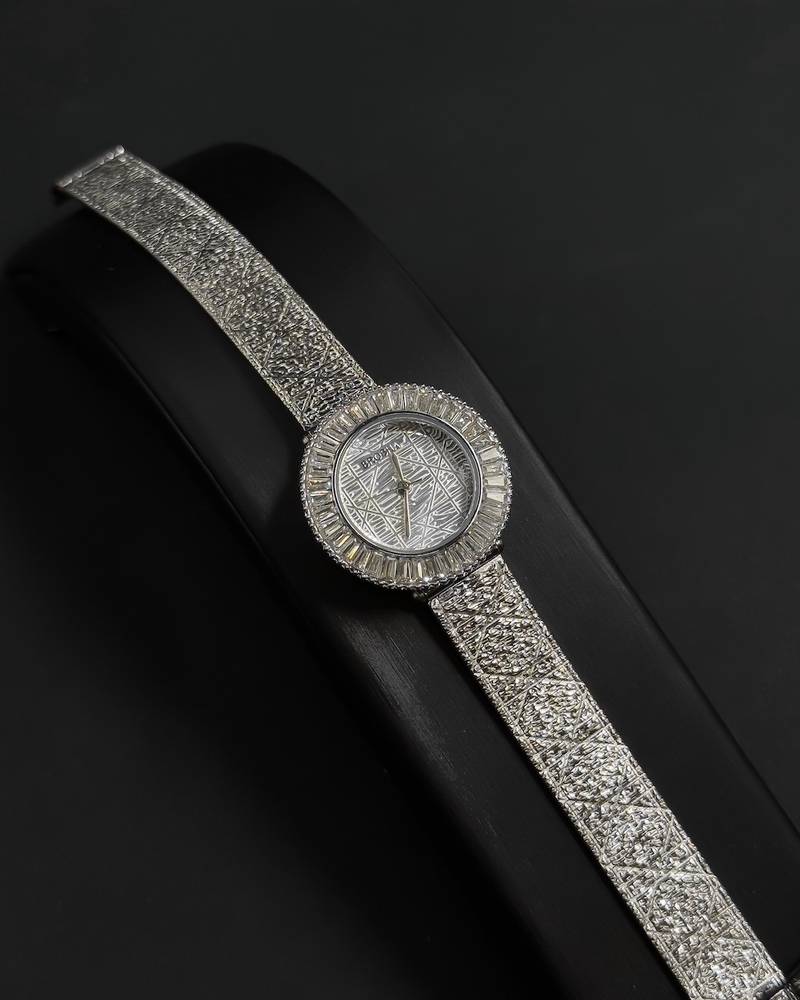 A women's watch adorned with a frame and engraved details