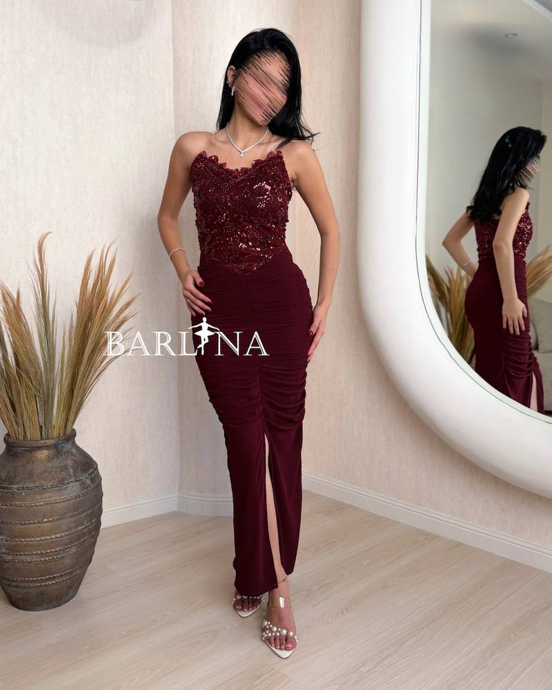 Burgundy dress with a front slit and a gathered design