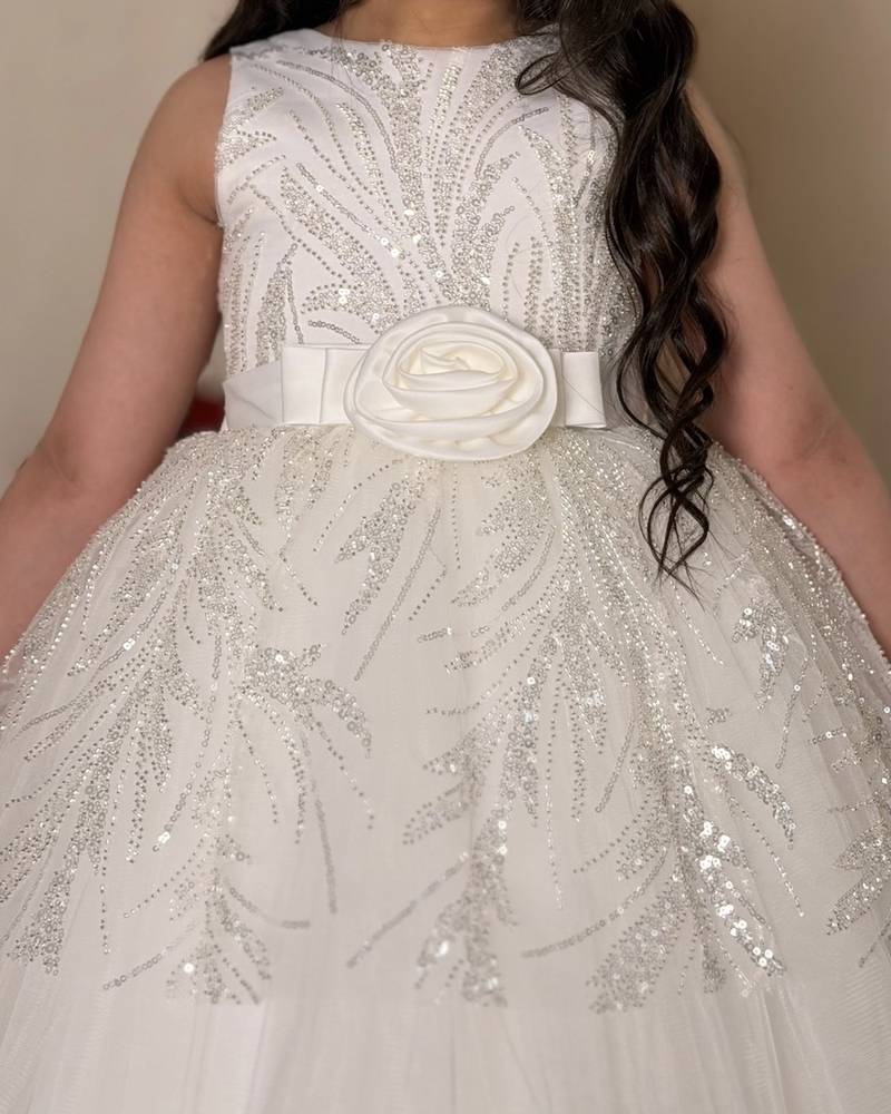 White girl's dress decorated with glitter patterns and a belt
