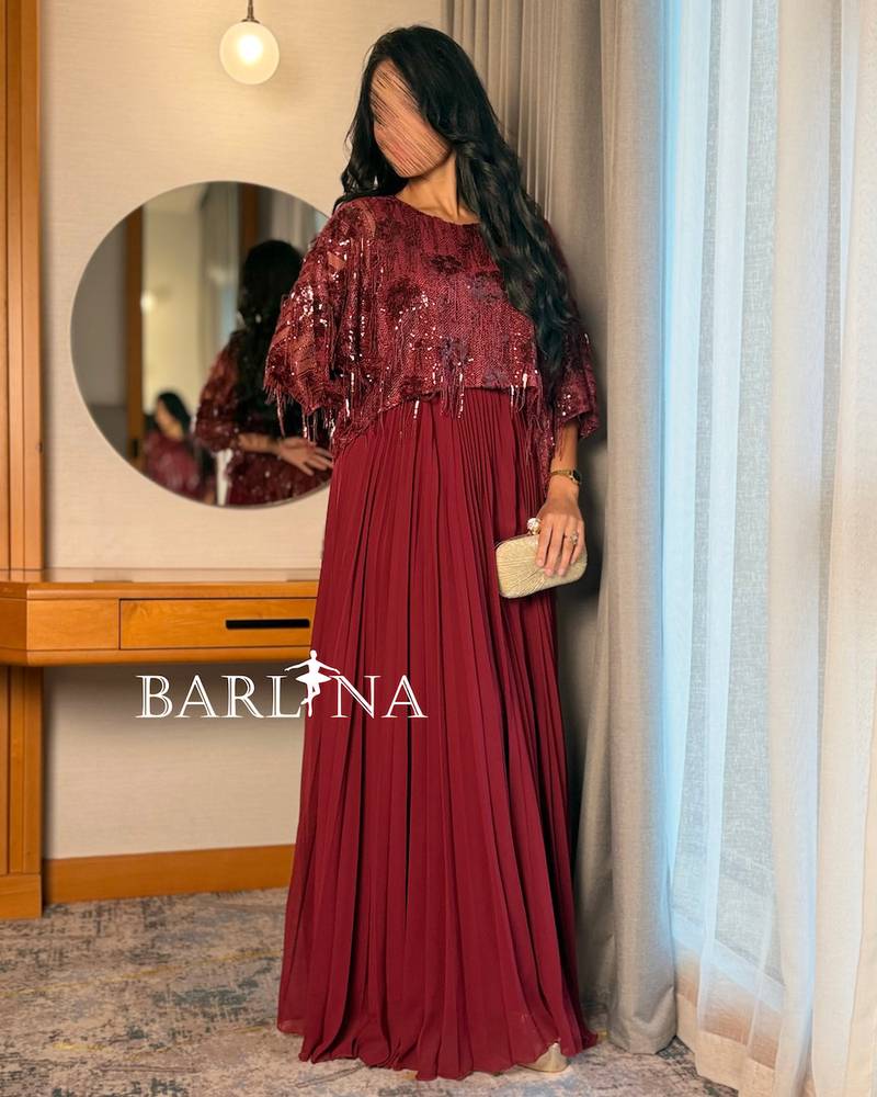 A wide, burgundy dress with shimmering sequins and soft pleats